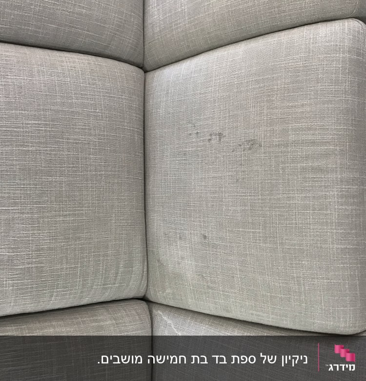 ספה אפורה עם כתמים ומכשיר ניקוי